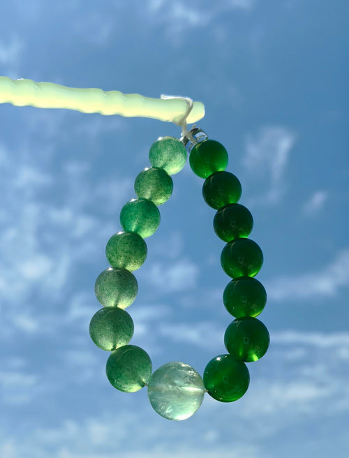 Great Forest Wood — 大林木 bracelet held against blue sky